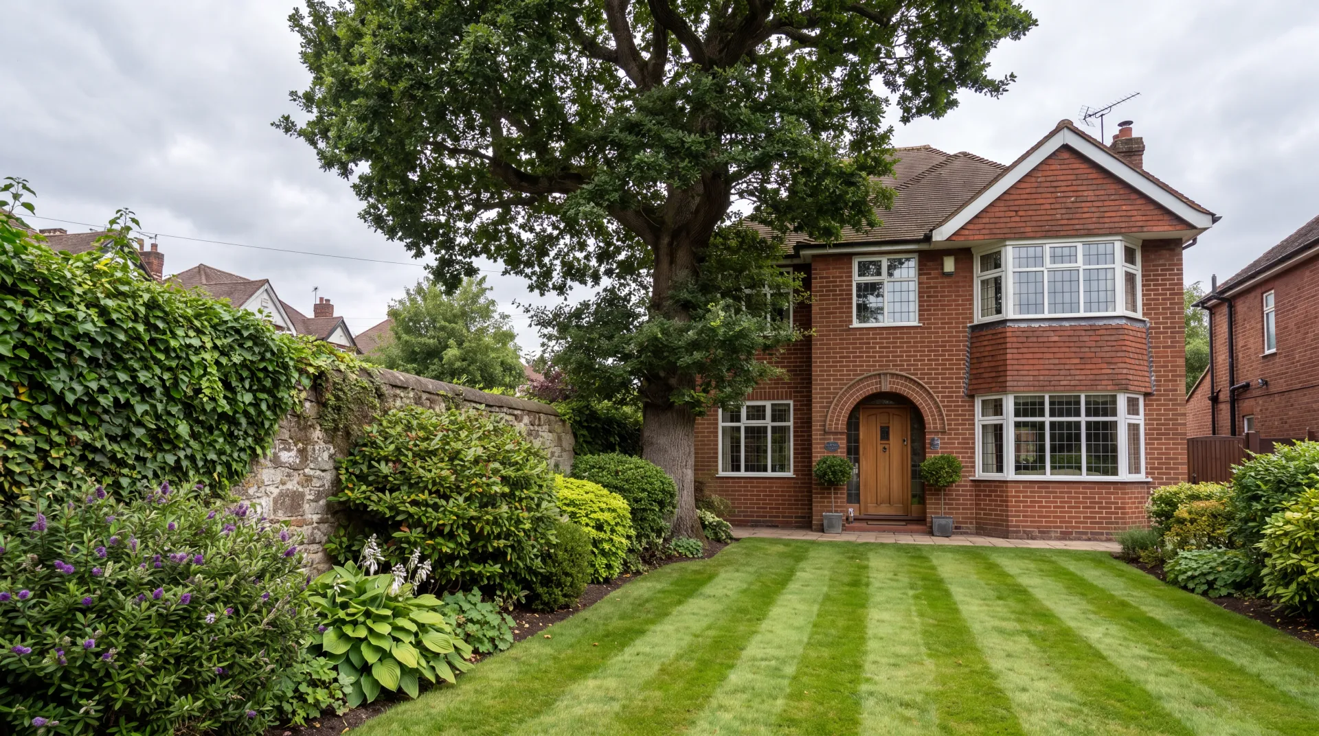 Detached 1930s house beneath a mature oak tree