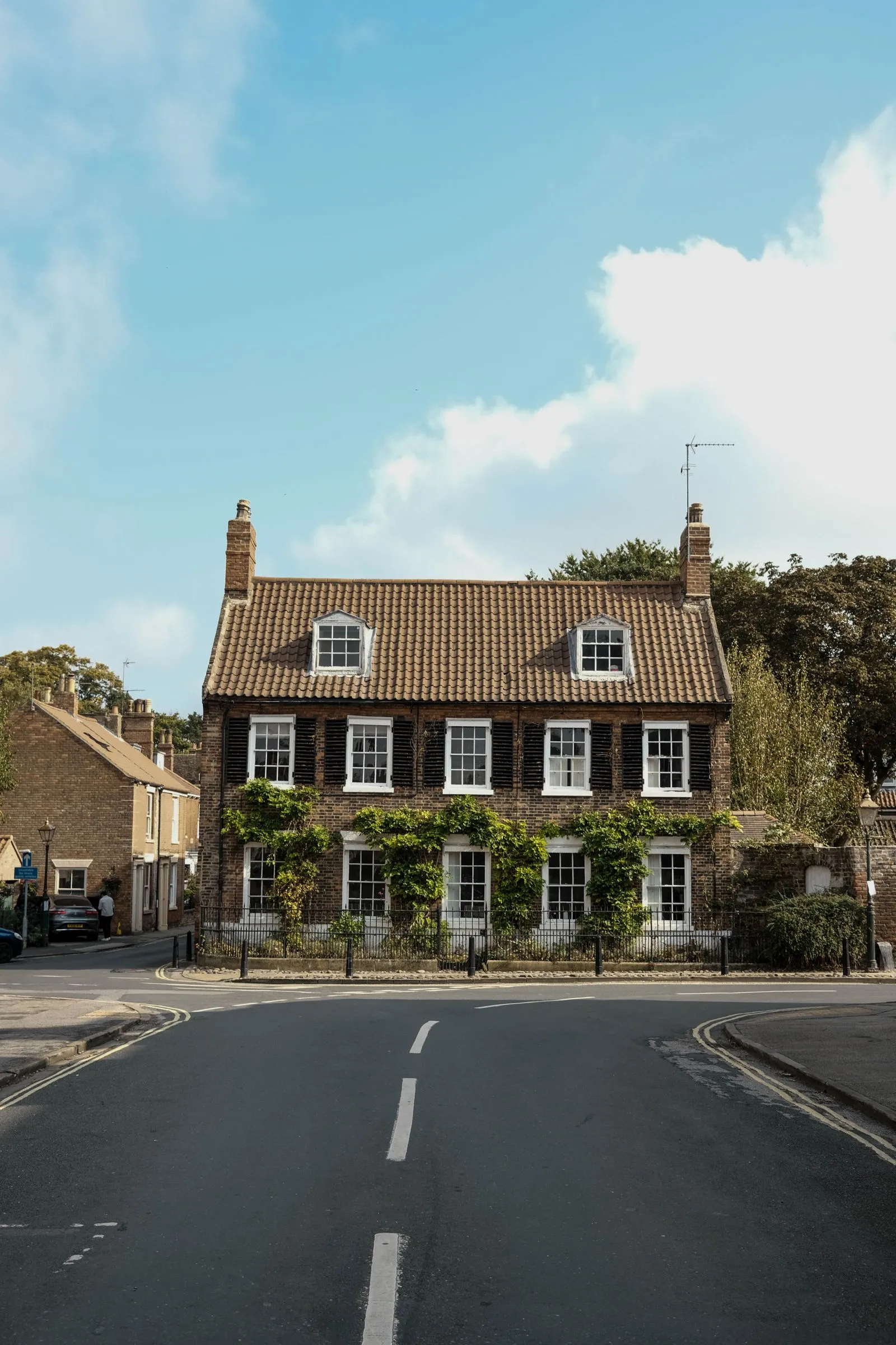 Period brick house with climbing greenery