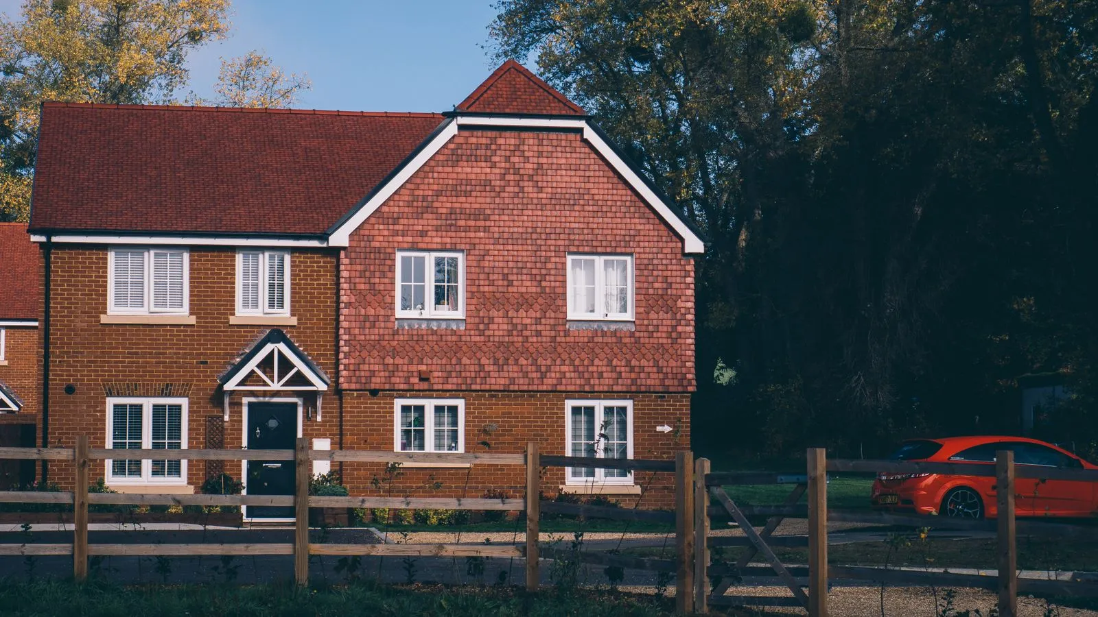 Red-brick family home against mature trees